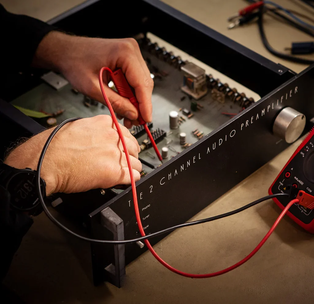 technician testing amplifier components with probes