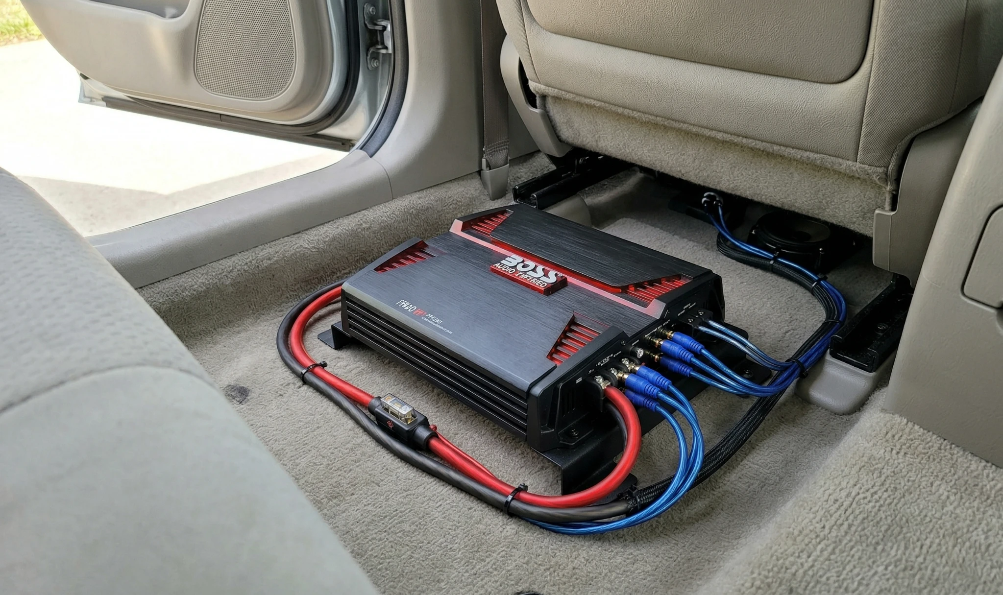 BOSS Audio PF1800 amplifier installed under car seat with visible wiring and power connections