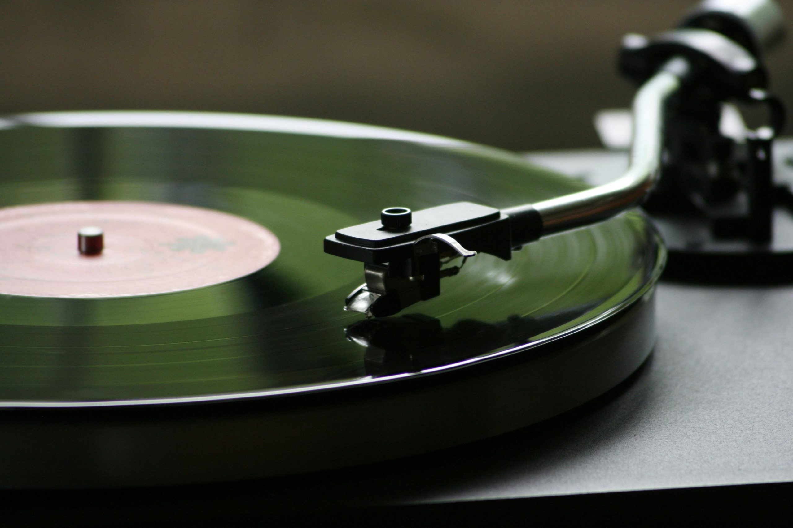 Close-up of a vinyl record spinning on a turntable with the stylus tracking the groove
