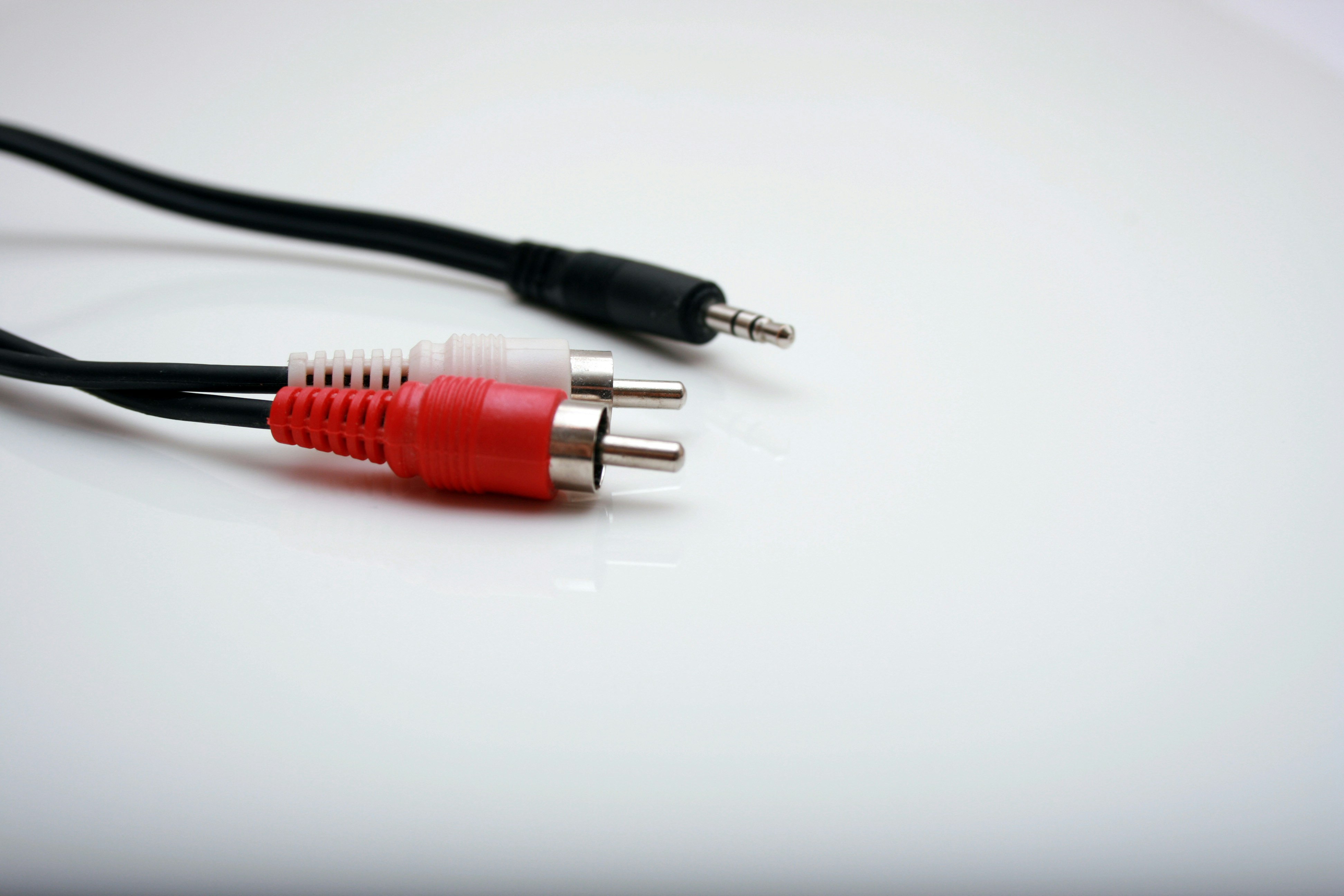 Red and white RCA audio connectors alongside a 3.5mm plug on a white surface