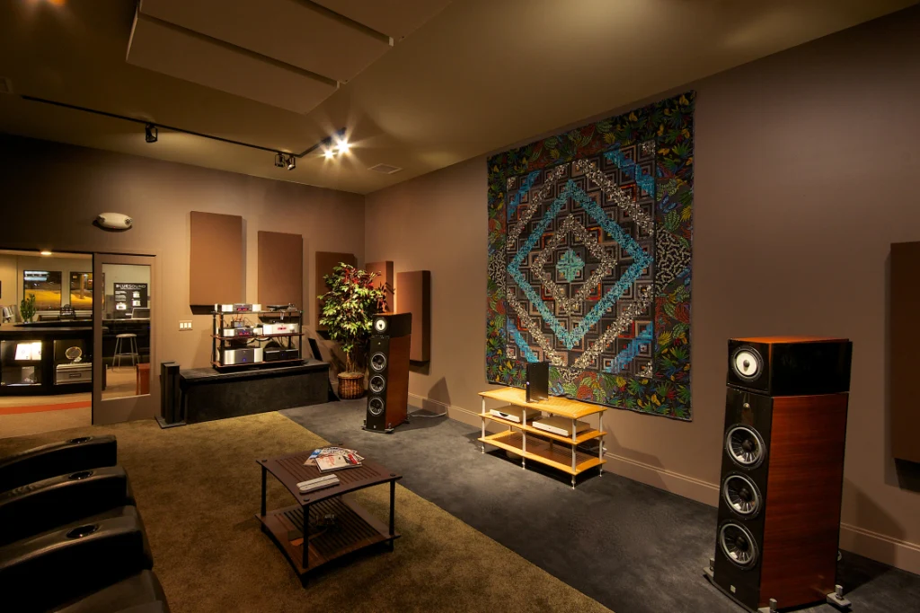 High-end audiophile listening room with acoustic panels, amplifiers, and reference speakers.