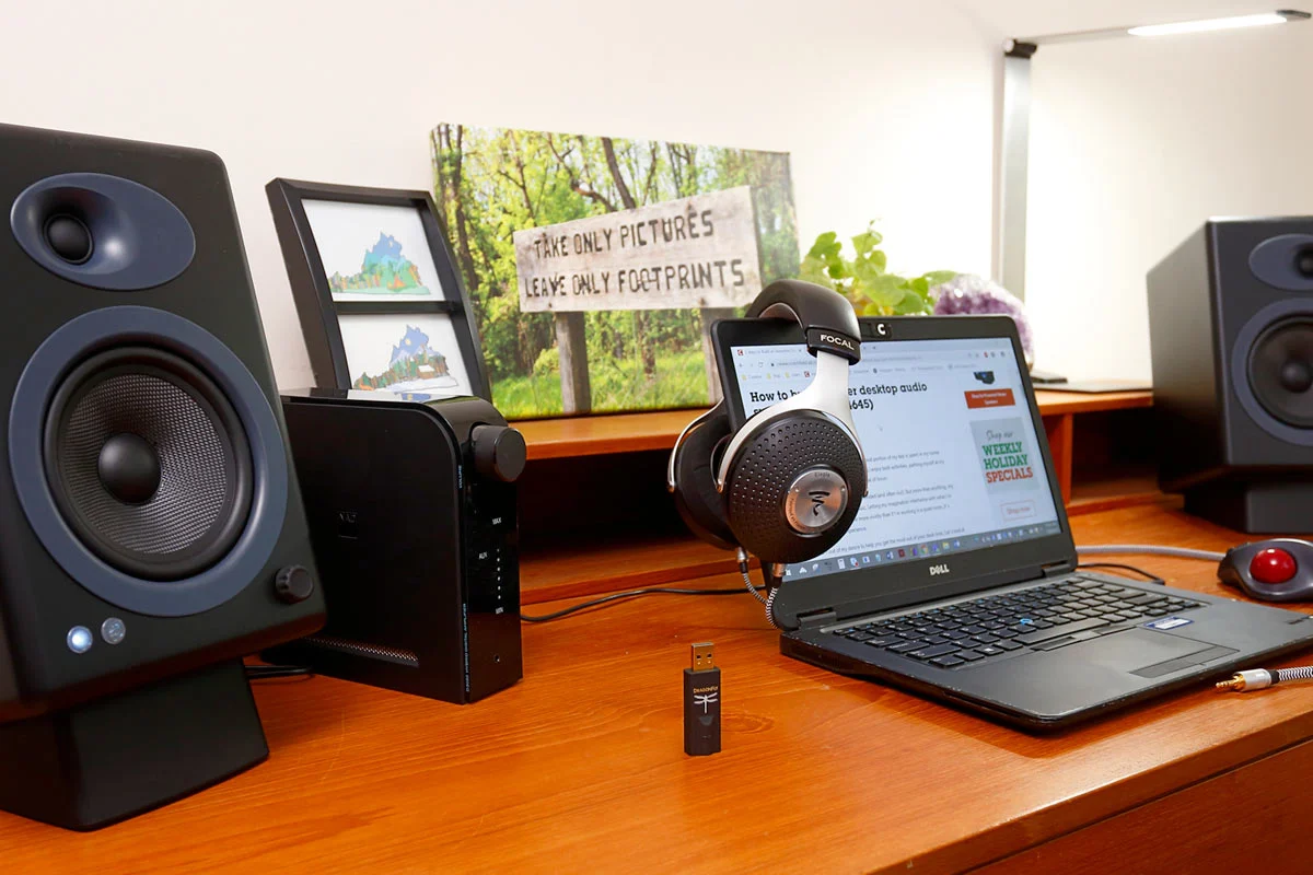 desktop audio setup with compact amplifier, bookshelf speakers, and laptop source