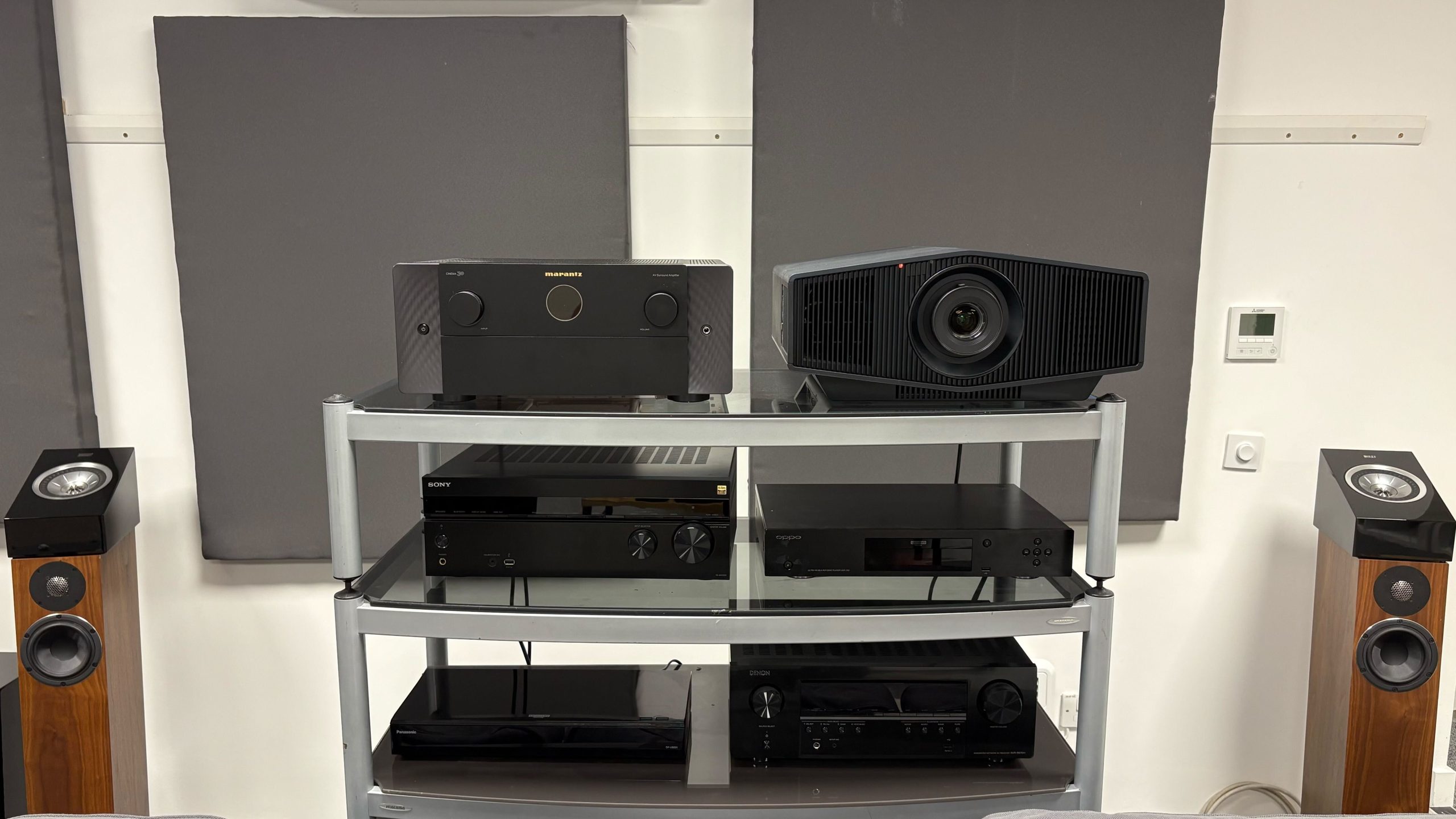 multiple amplifier brands arranged in a home audio rack for comparison