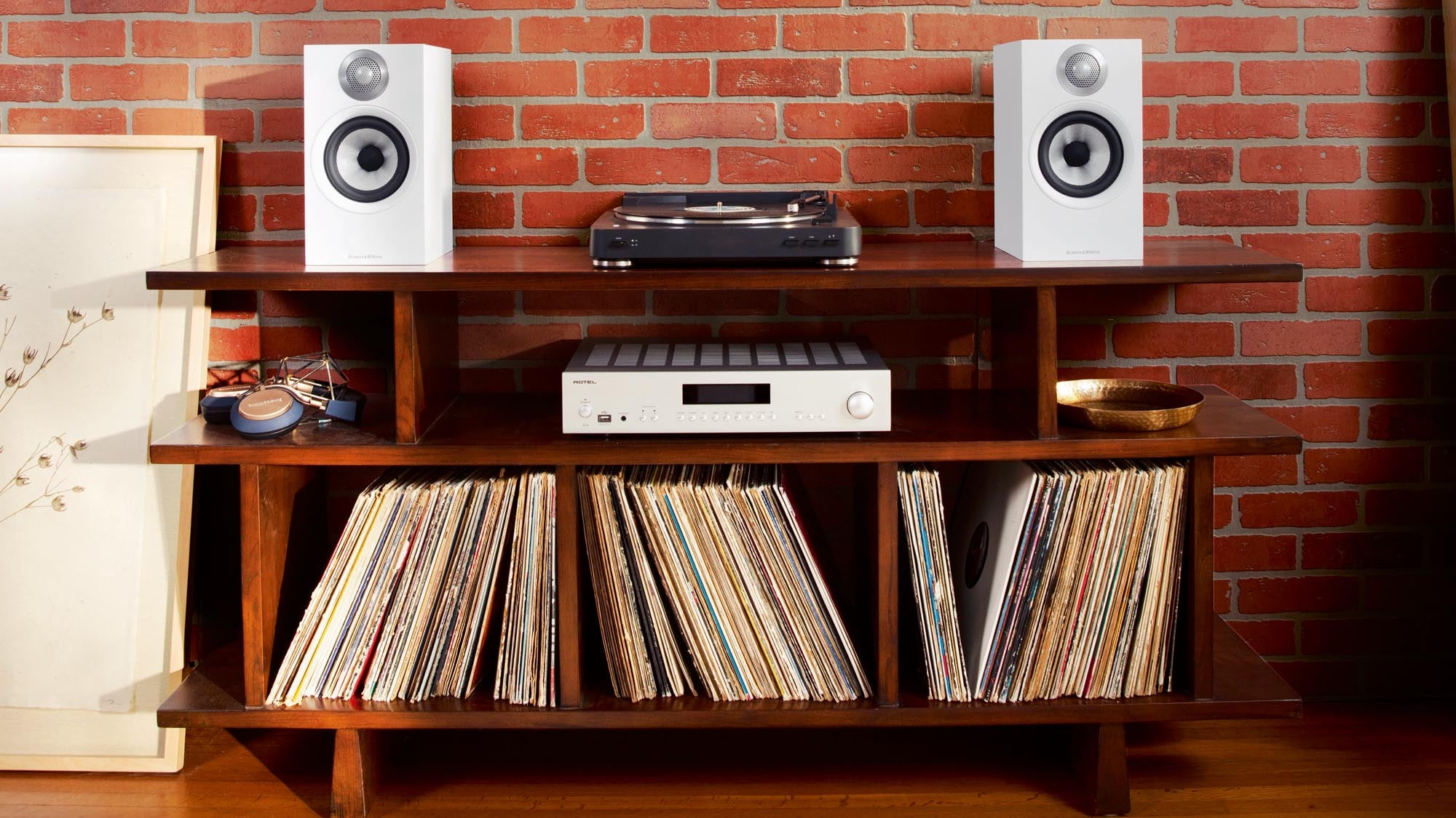 Simple home audio setup with bookshelf speakers, amplifier, and turntable on a wooden media console
