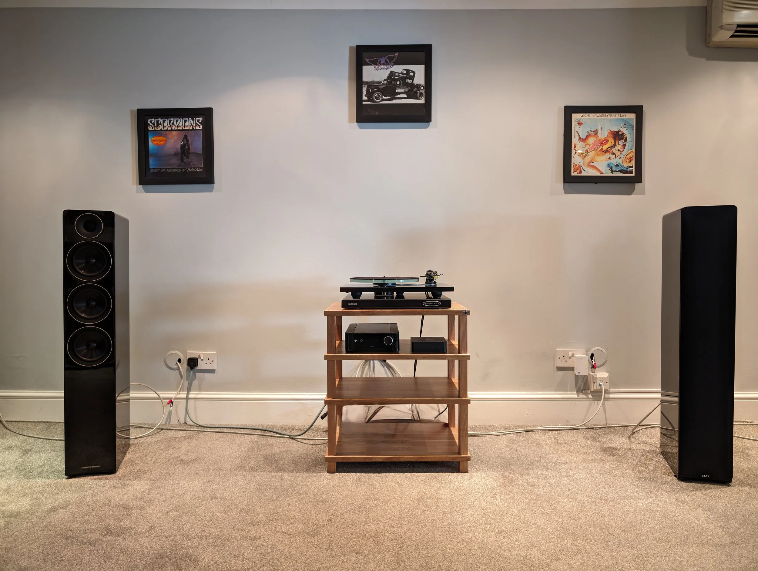 Symmetrical home audio setup with floorstanding speakers and amplifier showing a balanced system rather than an upgrade-focused change