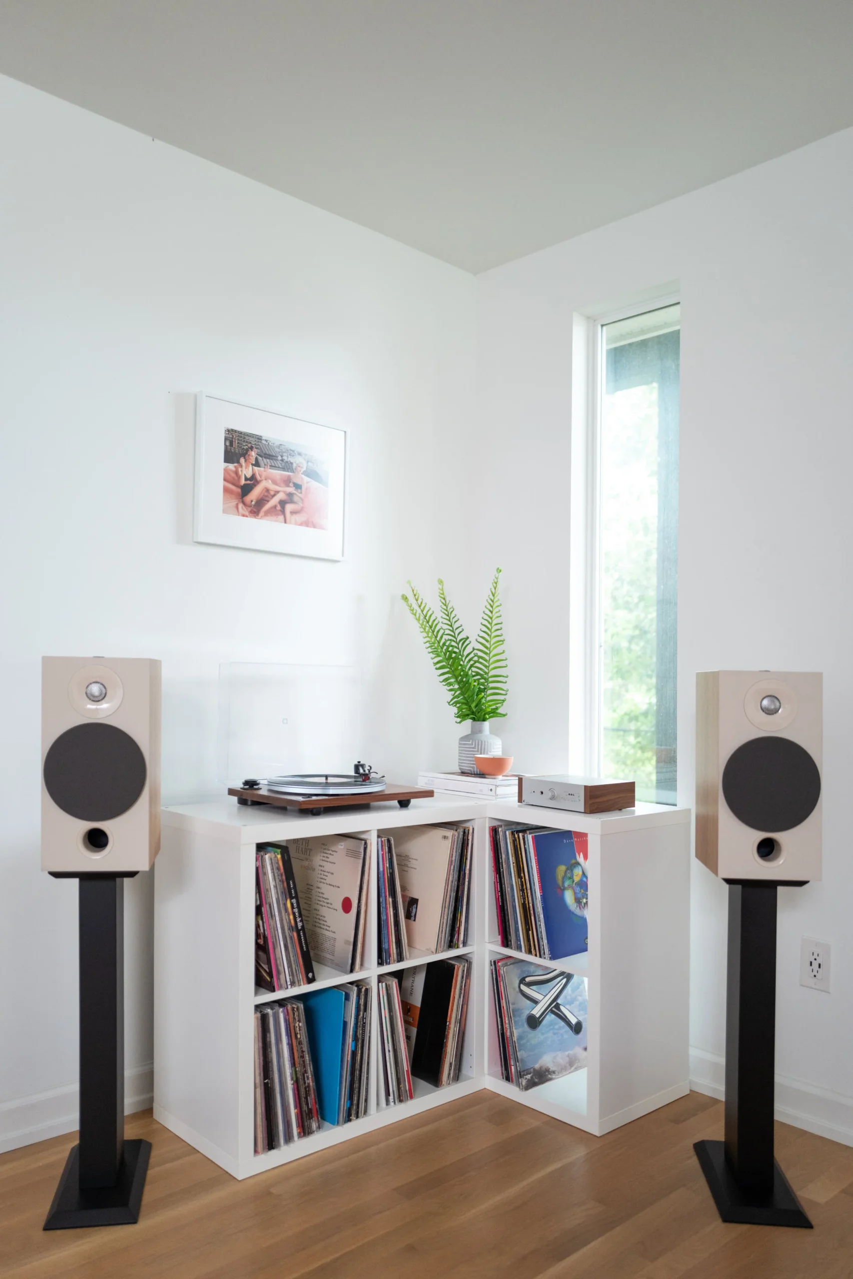 Beginner home audio setup with integrated amplifier, turntable, and bookshelf speakers on stands