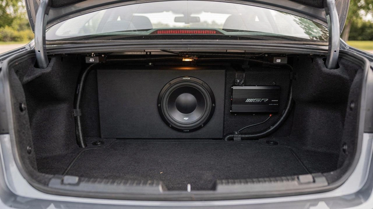 Monoblock car amplifier installed powering a subwoofer in a vehicle trunk