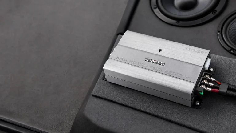Kenwood KAC-M3004 compact 4-channel car amplifier installed in vehicle with speakers