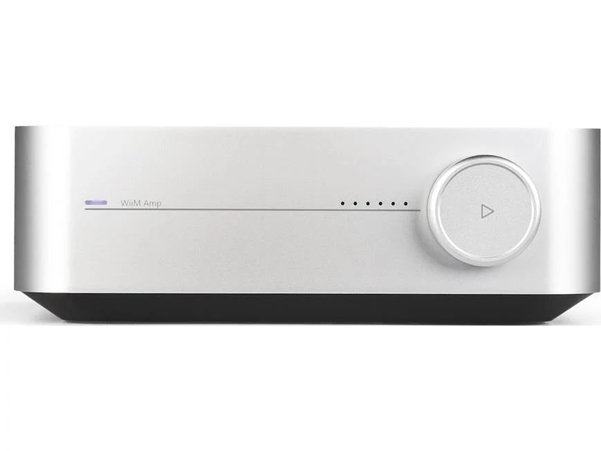 WiiM Amp streaming amplifier connected to passive bookshelf speakers in a modern living room