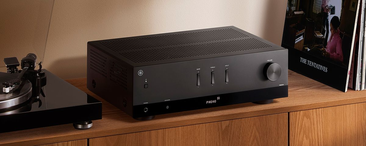 Yamaha R200A review: the black R200A stereo receiver on a wooden shelf next to a turntable and vinyl records
